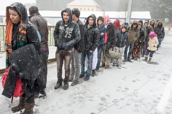 Flüchtlinge warten an der deutsch-österreichischen Grenze nahe Wegscheid (Bayern) während eines Schneeschauers auf ihre Einreise nach Deutschland.