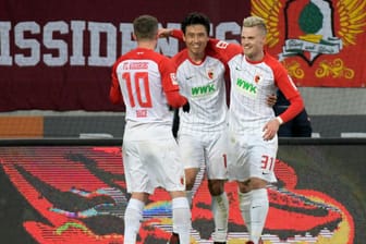 Augsburgs (l-r) Daniel Baier, Torschütze Ja-Cheol Koo und Philipp Max jubeln nach dem 1:0. Der FC geht nach dem Schlusspfiff als Sieger vom Platz.