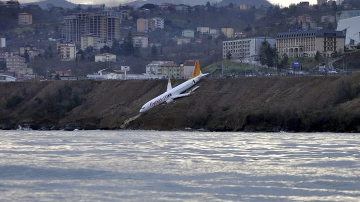 Ein Passagierflugzeug der türkischen Fluglinie Pegasus an einem steilen Abhang neben der Landebahn, nur wenige Meter vom Schwarzen Meer entfernt.