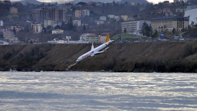 Ein Passagierflugzeug der türkischen Fluglinie Pegasus an einem steilen Abhang neben der Landebahn, nur wenige Meter vom Schwarzen Meer entfernt. Ein Passagierflugzeug der türkischen Fluglinie Pegasus an einem steilen Abhang neben der Landebahn, nur wenige Meter vom Schwarzen Meer entfernt.