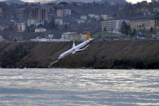 Ein Passagierflugzeug der türkischen Fluglinie Pegasus an einem steilen Abhang neben der Landebahn, nur wenige Meter vom Schwarzen Meer entfernt.