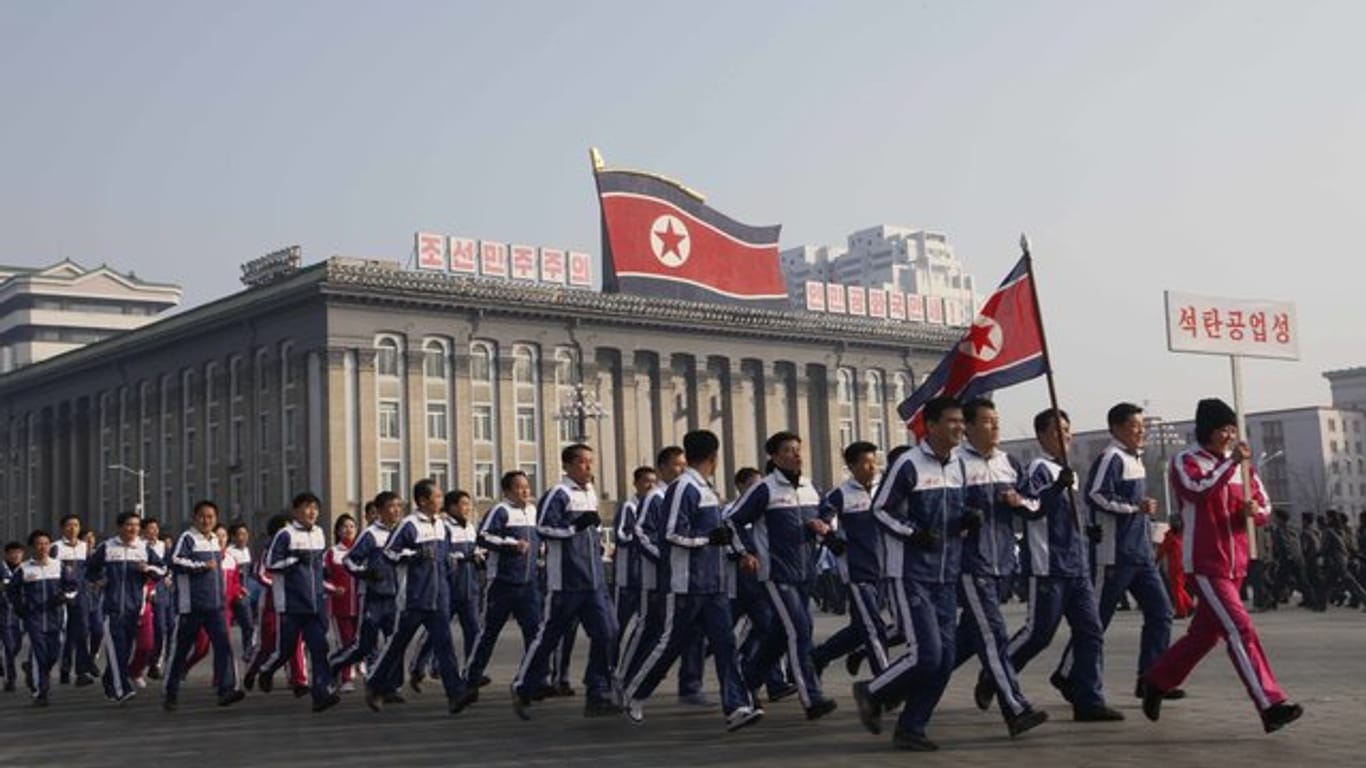 Eine Gruppe nordkoreanischer Regierungsbeamter joggt in Pjöngjang.