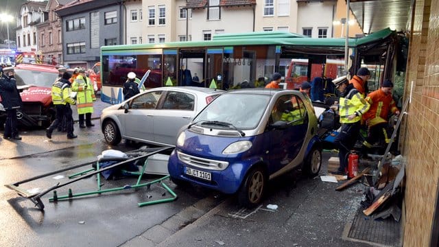 Nach dem Unfall mit einem Schulbus, stehen Einsatzkräfte der Feuerwehr und Polizei am Unfallort. Nach dem Unfall mit einem Schulbus, stehen Einsatzkräfte der Feuerwehr und Polizei am Unfallort.