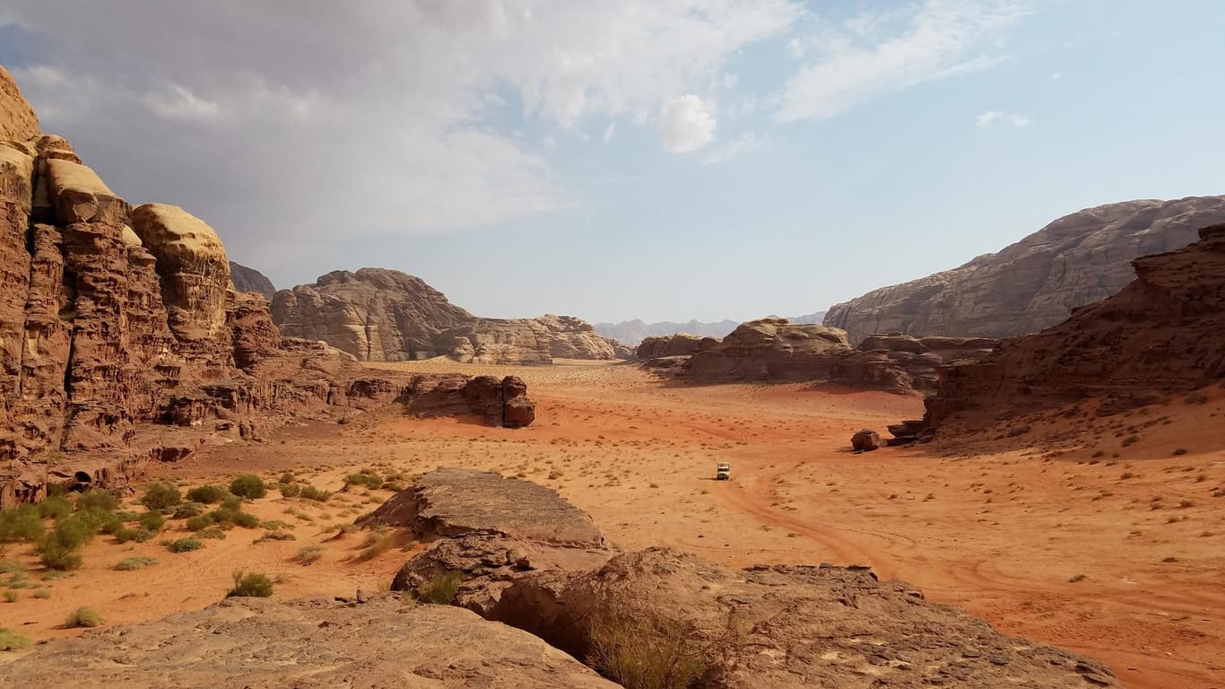 Mit einem Jeep durch die Fels- und Sandwüste cruisen, Wandmalereien besichtigen und beim Tee mit Beduinen die nomadische Kultur kennenlernen: Die Wadi Rum in Jordanien.
