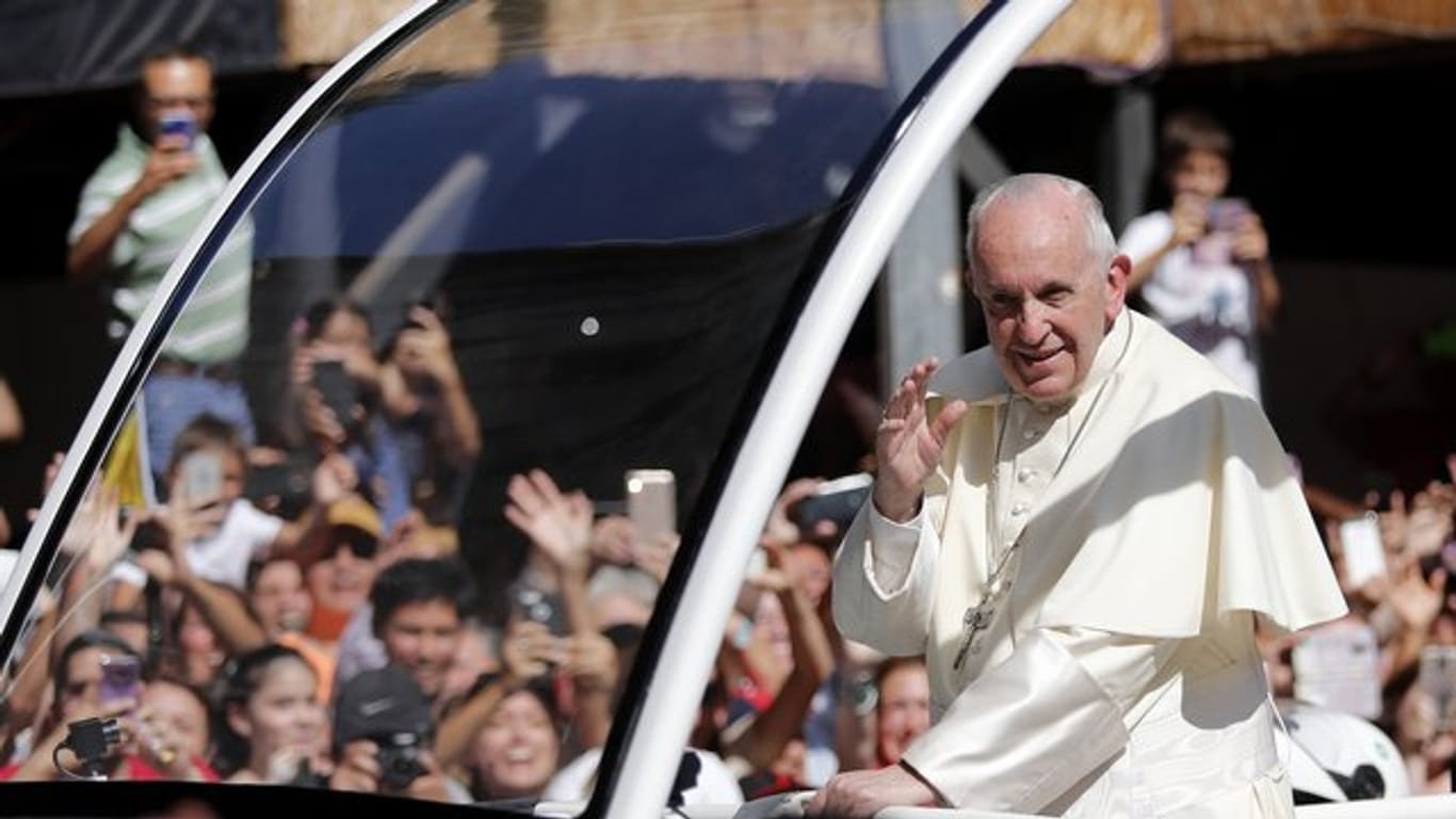 Papst Franziskus winkt in Santiago de Chile aus seinem Papamobil den Menschen zu.