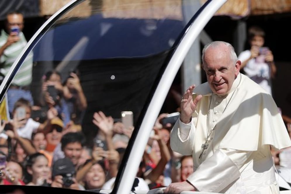 Papst Franziskus winkt in Santiago de Chile aus seinem Papamobil den Menschen zu.