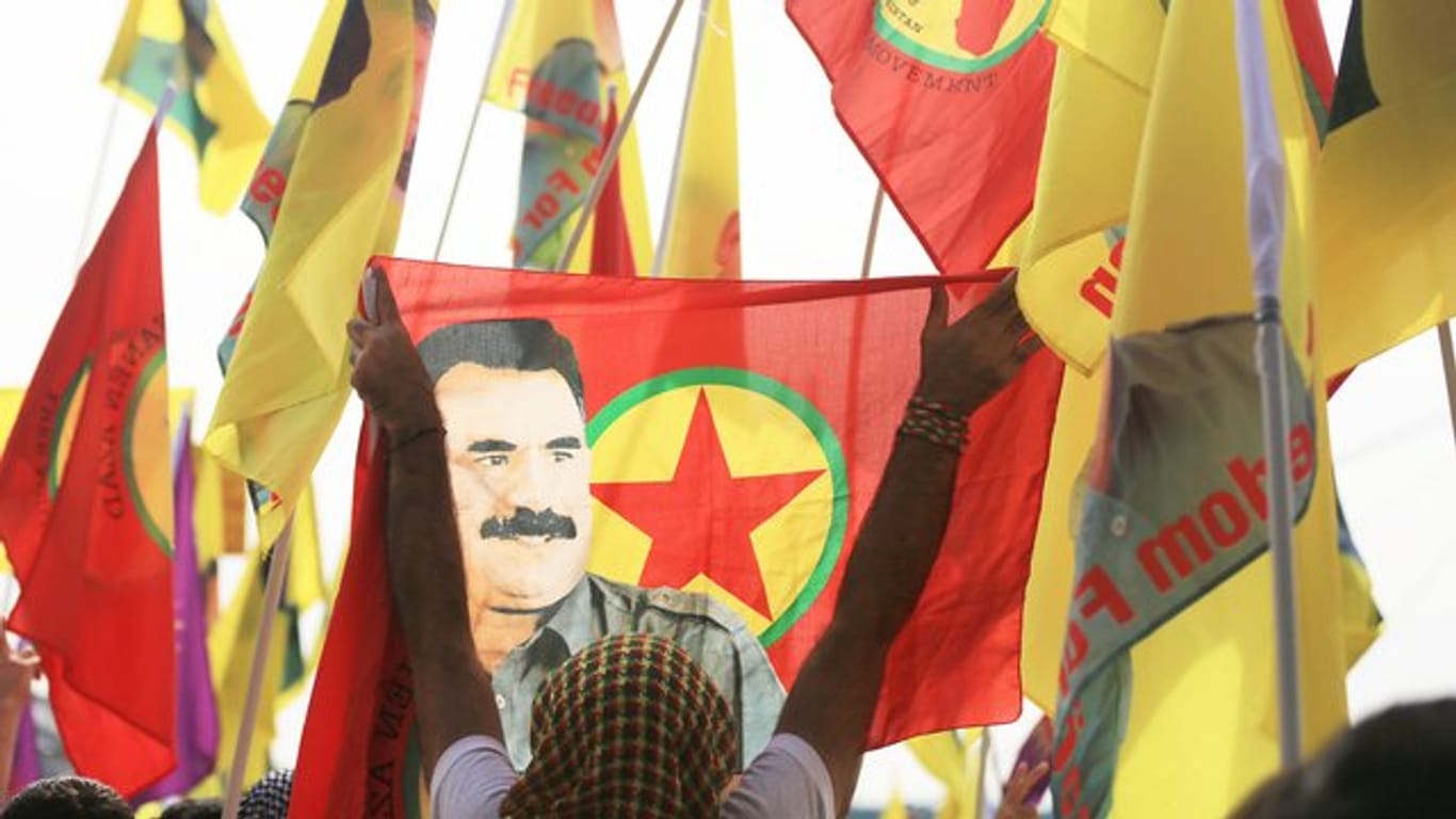 Verbotene Fahnen mit dem Abbild des PKK-Anführers Abdullah Öcalan bei einer Kundgebung in Köln.