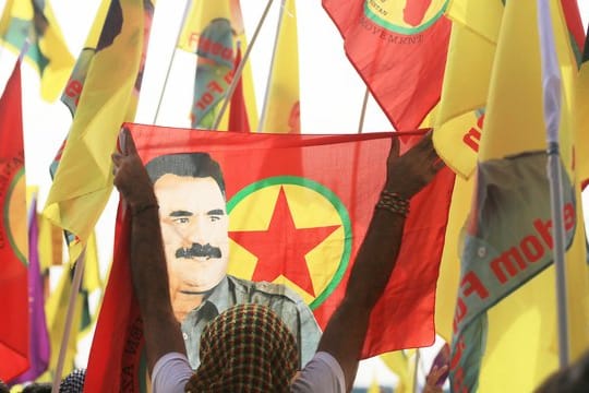 Verbotene Fahnen mit dem Abbild des PKK-Anführers Abdullah Öcalan bei einer Kundgebung in Köln.
