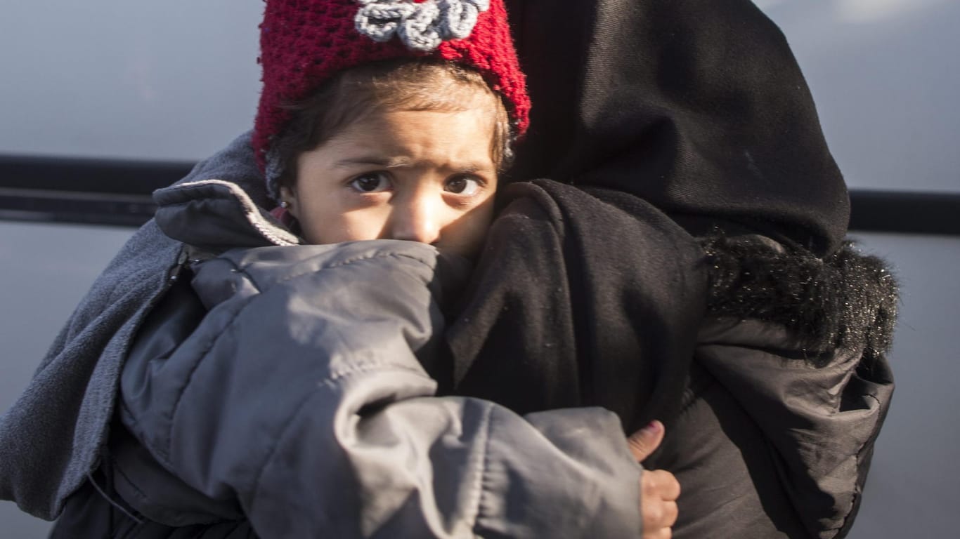 Ein Flüchtluingskind auf dem Arm seiner Mutter im Hafen von Dikili: Die Union will den Familiennachzug für Angehörige von Flüchtlingem mit eingeschränktem Schutzstatus bis Juli aussetzen.
