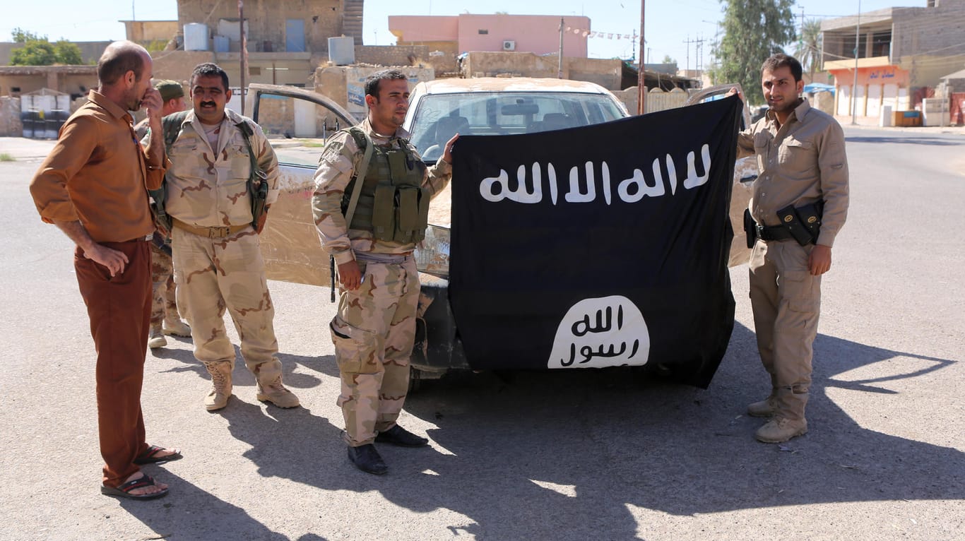 Irakische Soldaten posieren mit einer IS-Flagge: Die Deutsche habe dem IS bei seinen Taten geholfen und sei an einem Angriff auf irakische Sicherheitskräfte beteiligt gewesen.