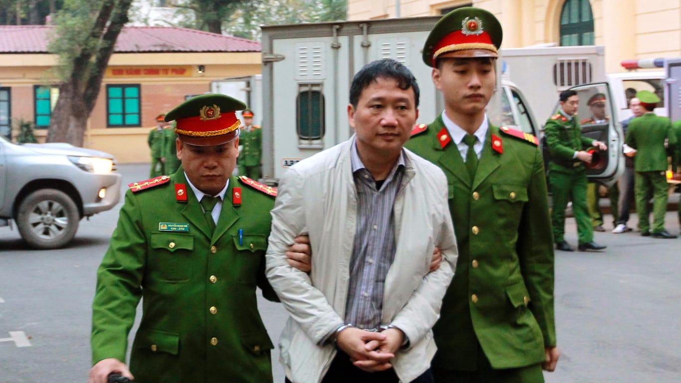 Polizisten führen den angeklagten Geschäftsmann Trinh Xuan Thanh zu einem Gericht in Hanoi (Vietnam): Das Gericht verurteilte den mutmaßlich aus Deutschland entführten Geschäftsmann zu lebenslanger Haft.