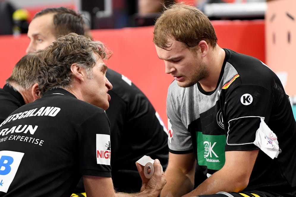 Paul Drux (r.) mit Physiotherapeut Peter Gräschus: Der Nationalspieler hat sich gegen Dänemark das Knie verdreht und fällt nun für den Rest der EM aus.