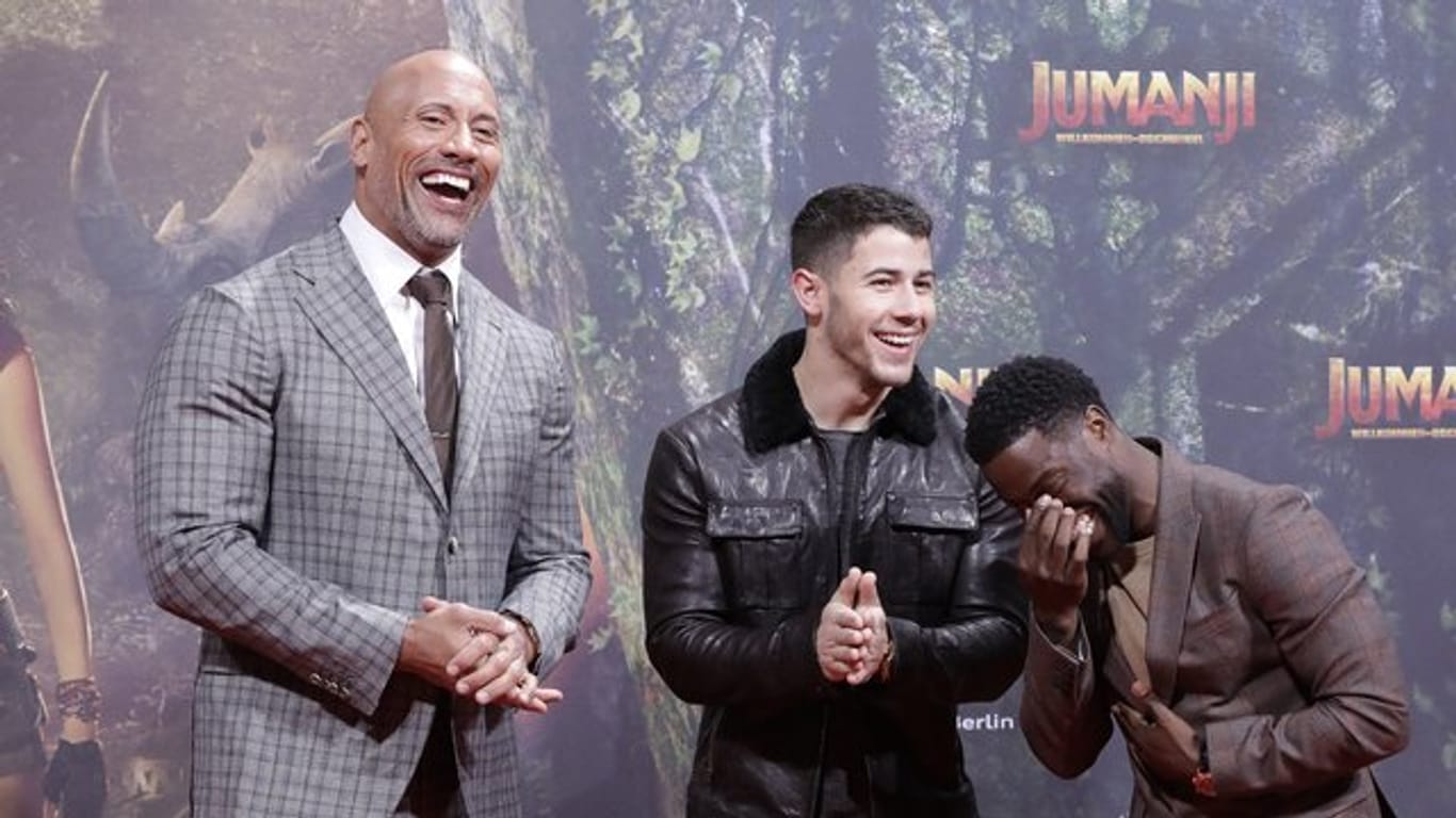 Dwayne Johnson (l-r), Nick Jonas und Kevin Hart amüsieren sich bei der "Jumanji"-Premiere in Berlin.