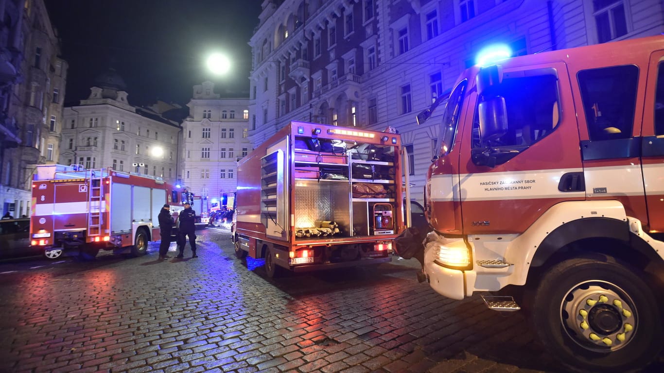Feuerwehrleute und Sanitäter stehen am 20.01.2018 vor einem Hotel in Prag (Tschechien), in dem ein Brand Dutzende Verletzte forderte.