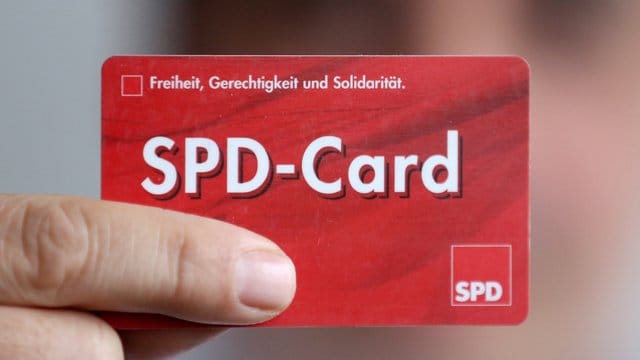 Ein SPD Mitglied zeigt sein Parteibuch im Checkkartenformat.