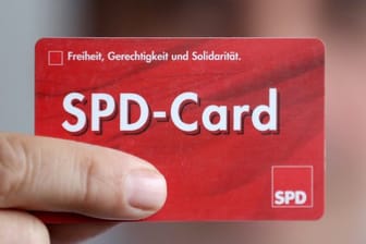 Ein SPD Mitglied zeigt sein Parteibuch im Checkkartenformat.