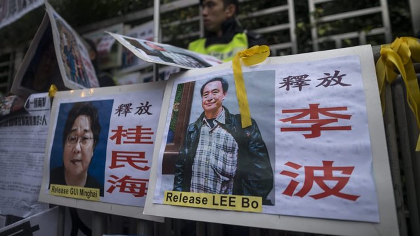 Ein Bild von Gui Minhai (l) und eines der anderen ehemals vermissten Buchhändler hängt in Hongkong.