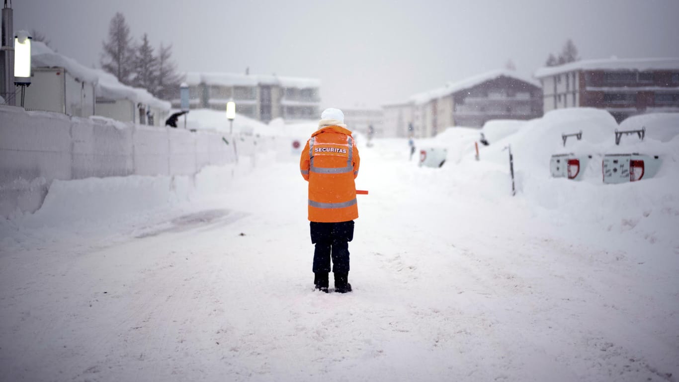 Wachmann in Davos. Wegen der Schneemassen haben Teilnehmer Schwierigkeiten, das Weltwirtschaftsforum zu erreichen.
