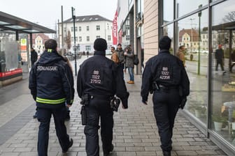 Ein Mitarbeiter des Ordnungsamtes und zwei Beamte der Bereitschaftspolizei gehen Streife vor einem Einkaufszentrum in Cottbus: Die Stadt wurde zum Schauplatz von hässlichen Angriffen zwischen Deutschen und Ausländern.
