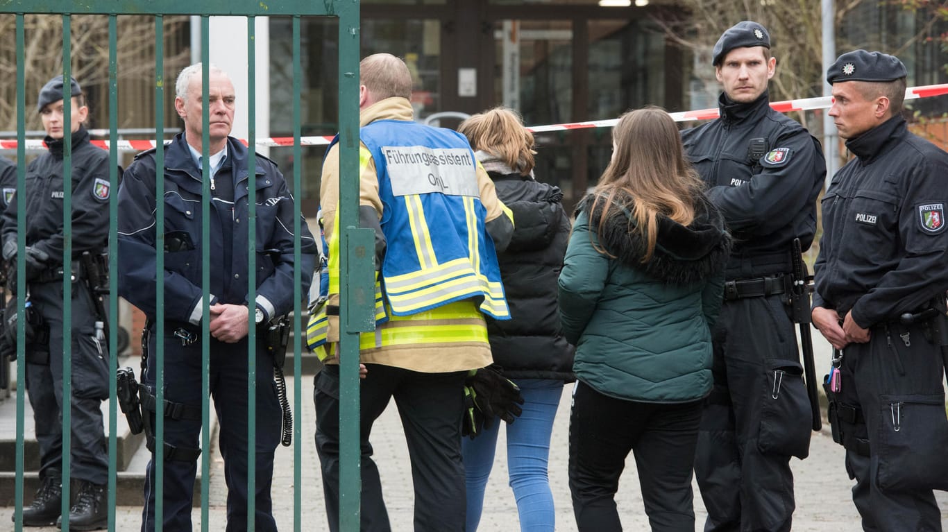 Polizisten begleiten am Dienstag Schüler über den Pausenhof: Nach der Bluttat beginnt in der Käthe-Kollwitz-Gesamtschule in Lünen wieder der Unterricht.