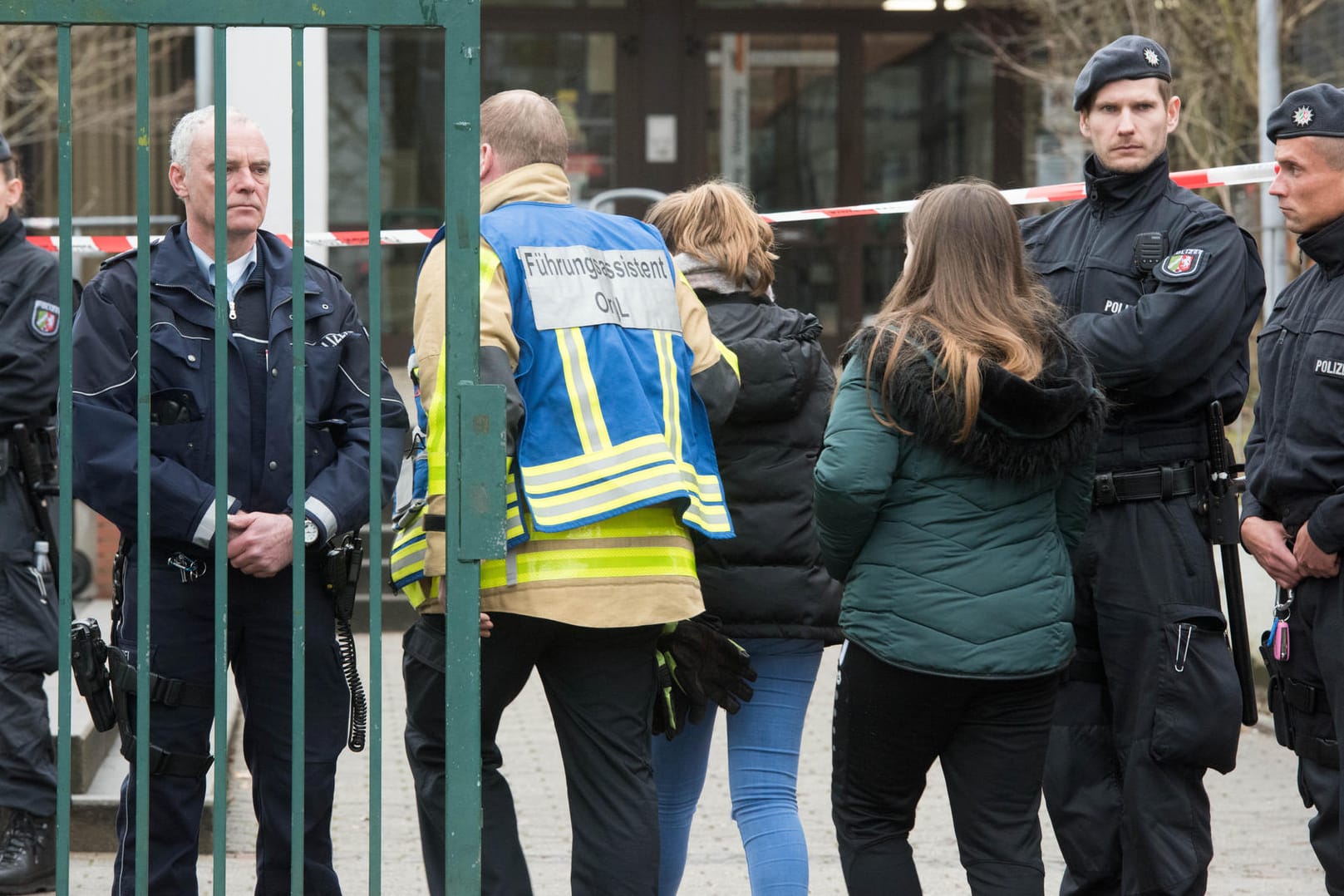 Polizisten begleiten am Dienstag Schüler über den Pausenhof: Nach der Bluttat beginnt in der Käthe-Kollwitz-Gesamtschule in Lünen wieder der Unterricht.