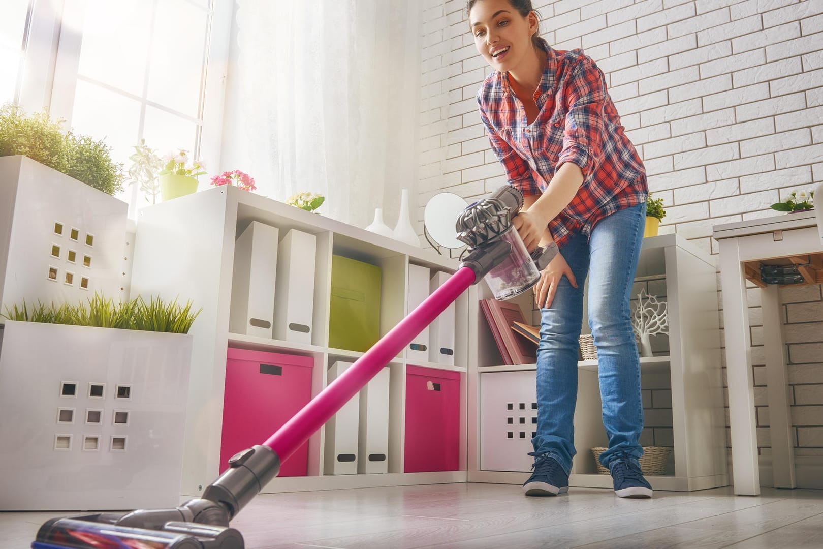 Eine Frau saugt mit einem kabellosen Handstaubsauger von Dyson: Stiftung Warentest hat mehrere solcher Staubsauger in ihrem aktuellen Heft getestet.