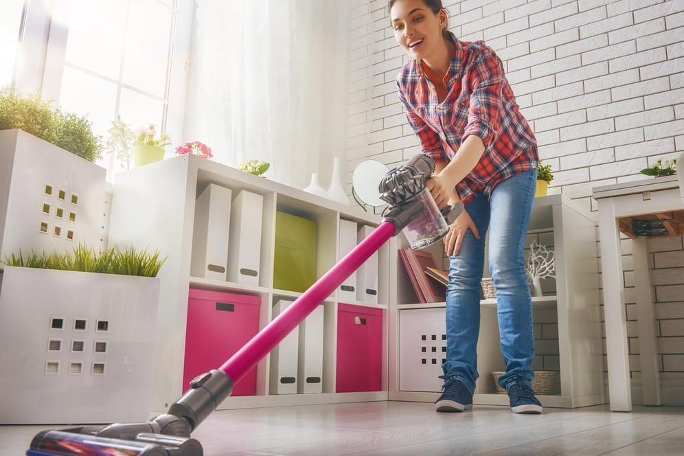 Eine Frau saugt mit einem kabellosen Handstaubsauger von Dyson: Stiftung Warentest hat mehrere solcher Staubsauger in ihrem aktuellen Heft getestet.