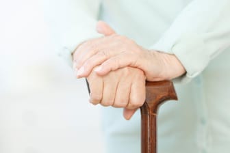 Senior stützt sich auf Gehstock: Im Alter kommt zur Museklschwäche die Angst vor Stürzen, Veränderungen der Muskulatur und Probleme mit dem Gleichgewicht hinzu.