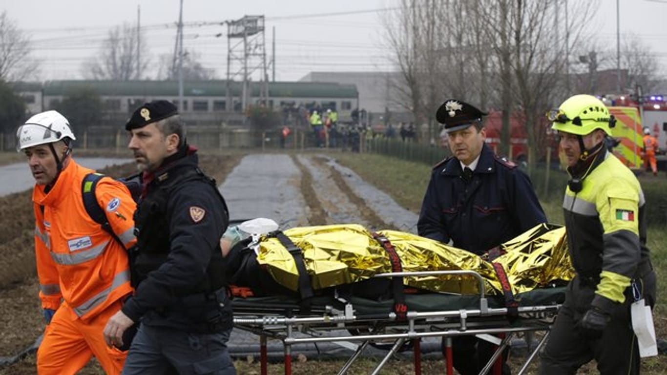 Ein Verletzter wird nach dem Zugunglück in der Nähe von Mailand geborgen.