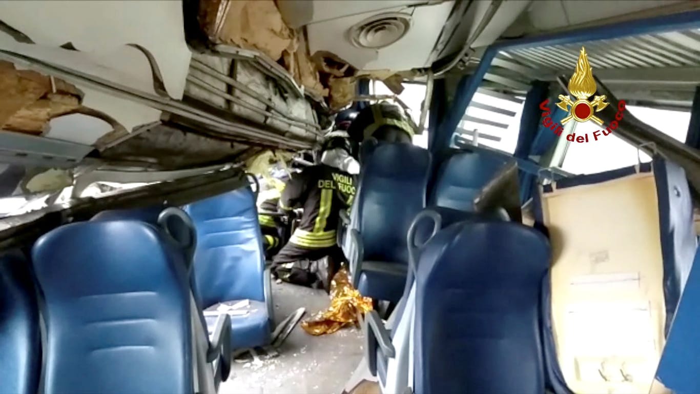 Einsatzkräfte bei Rettungsarbeiten im Zug: Mehrere Passagiere sollen nach dem Unglück in Waggons eingeschlossen sein.