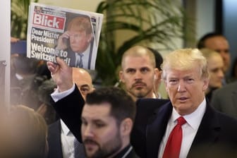 US-Präsident Trump winkt bei seiner Ankunft im Konferenzzentrum in Davos mit einem Exemplar der Schweizer Zeitung "Blick".