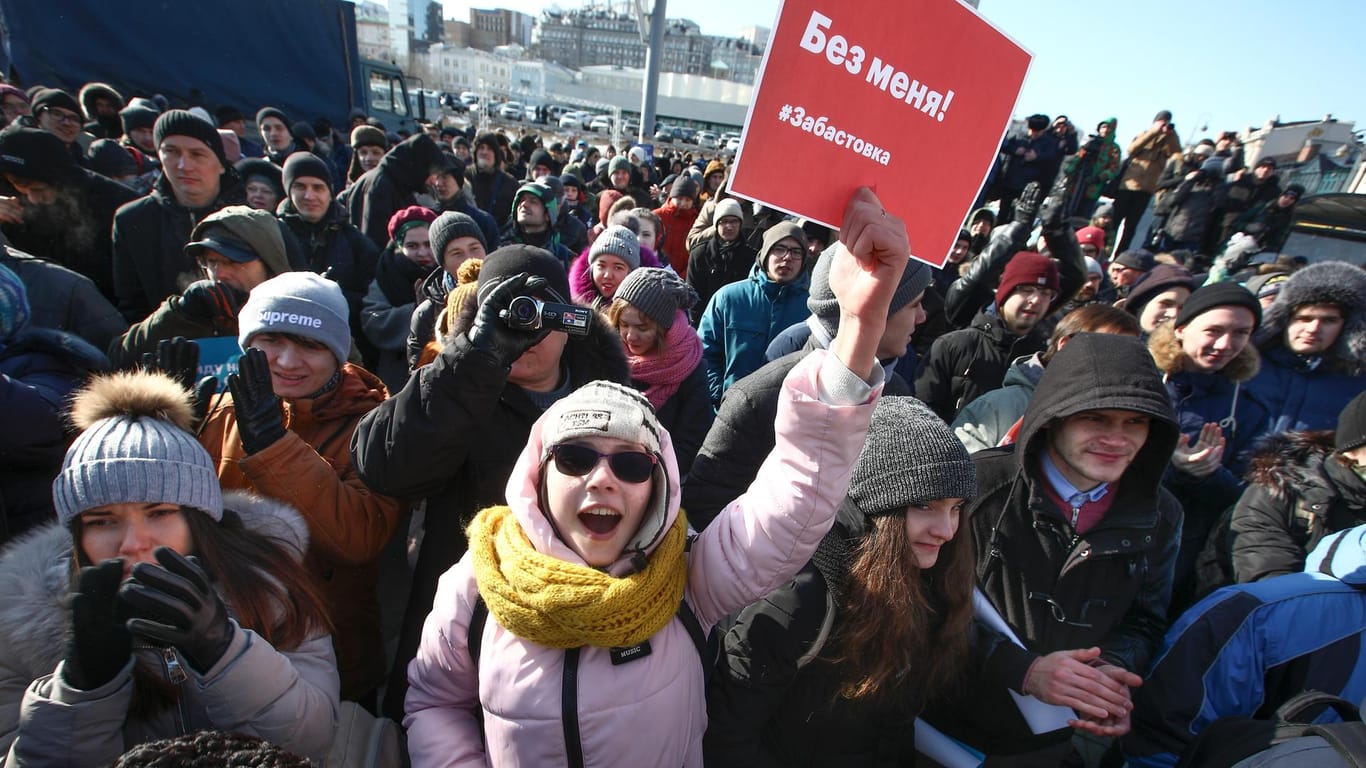 Demonstranten in Wladiwostok: Eine junge Frau hält ein Plakat mit der Aufschrift "Diese Wahlen ohne mich! Streik" in die Luft.