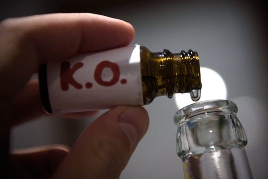 Jemand füllt "K.o.-Tropfen" in eine Bierflasche (Symbolbild): Die Initiative will gegen das Problem vorgehen.