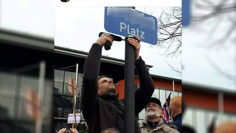 Männer um den Veranstaltungsleiter Marco Kurz hängen bei der Demo des "Frauenbündnisses" in Kandel ein Schild mit dem Namen des getöteten Mädchens auf.