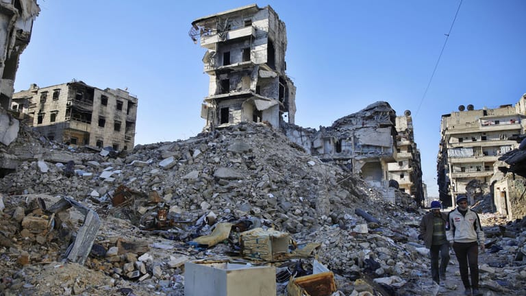 Zwei Männer durchsuchen in Aleppo (Syrien) die Trümmer: Durch den Bürgerkrieg sind 11,3 Millionen Syrer auf der Flucht.