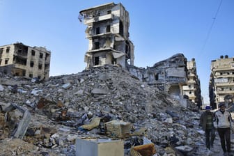 Zwei Männer durchsuchen in Aleppo (Syrien) die Trümmer: Durch den Bürgerkrieg sind 11,3 Millionen Syrer auf der Flucht.