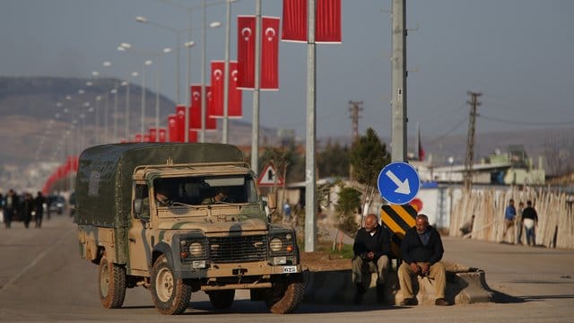 Ein Fahrzeug der türkischen Armee fährt am Grenzübergang Oncupinar unter türkischen Fahnen entlang. Ein Fahrzeug der türkischen Armee fährt am Grenzübergang Oncupinar unter türkischen Fahnen entlang.