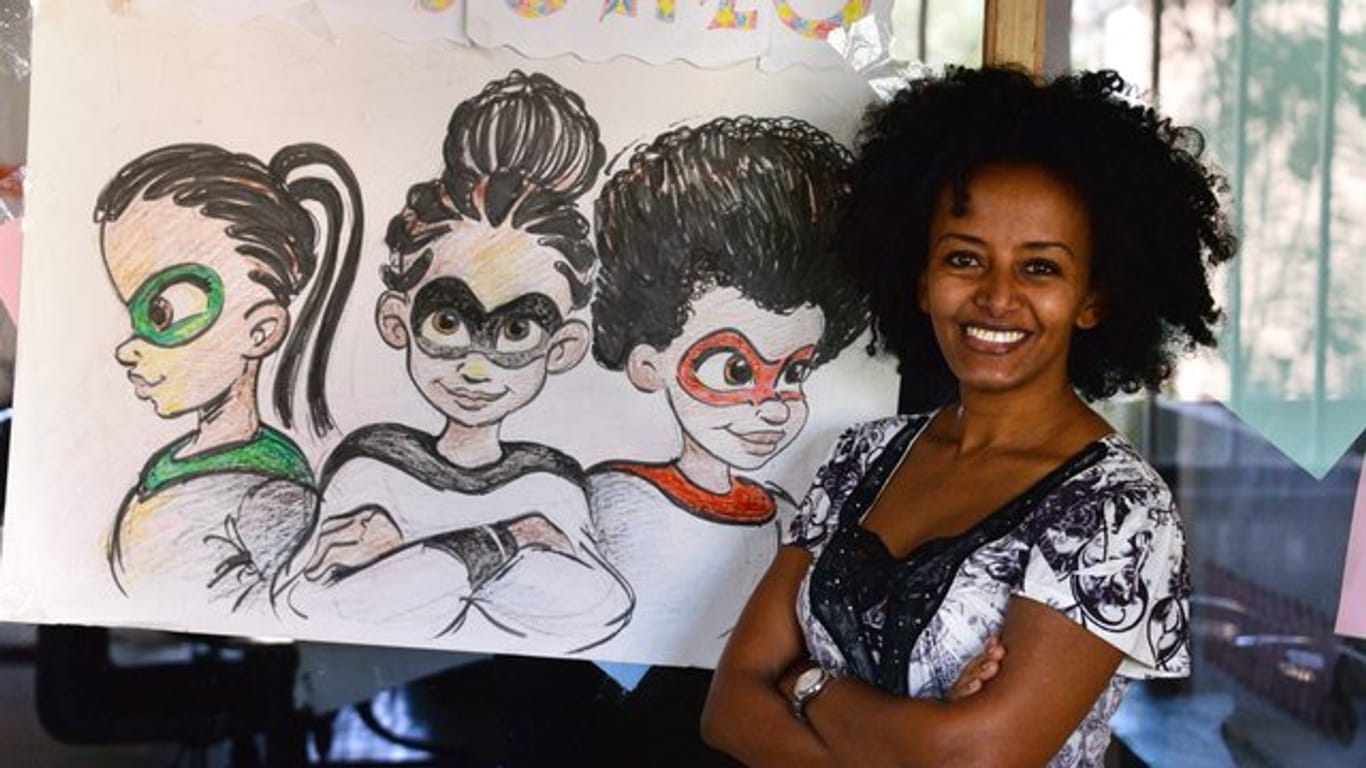 Bruktawit Tigabu, die Gründerin der Medienfirma Whiz Kids Workshop, neben einer Zeichnung mit ihren Figuren.
