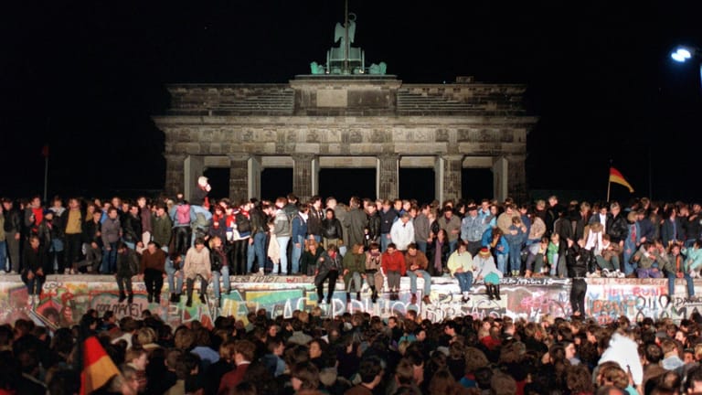 Jubelnde Menschen auf der Berliner Mauer am Brandenburger Tor am 10.11.1989. Die historische Sensation vom 9. November 1989 hat sich auch bei Roland Jahn eingebrannt.