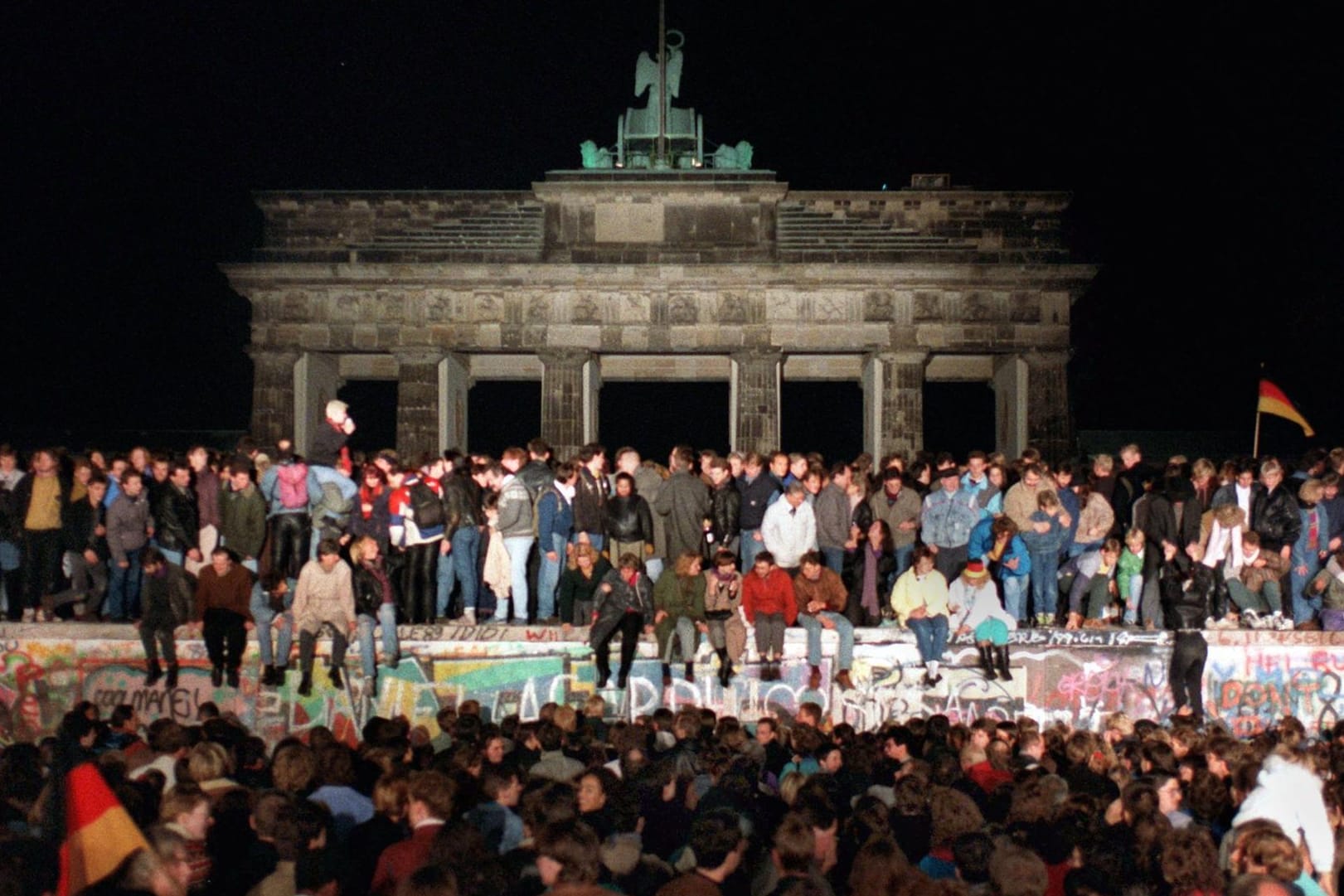 Jubelnde Menschen auf der Berliner Mauer am Brandenburger Tor am 10.11.1989. Die historische Sensation vom 9. November 1989 hat sich auch bei Roland Jahn eingebrannt.