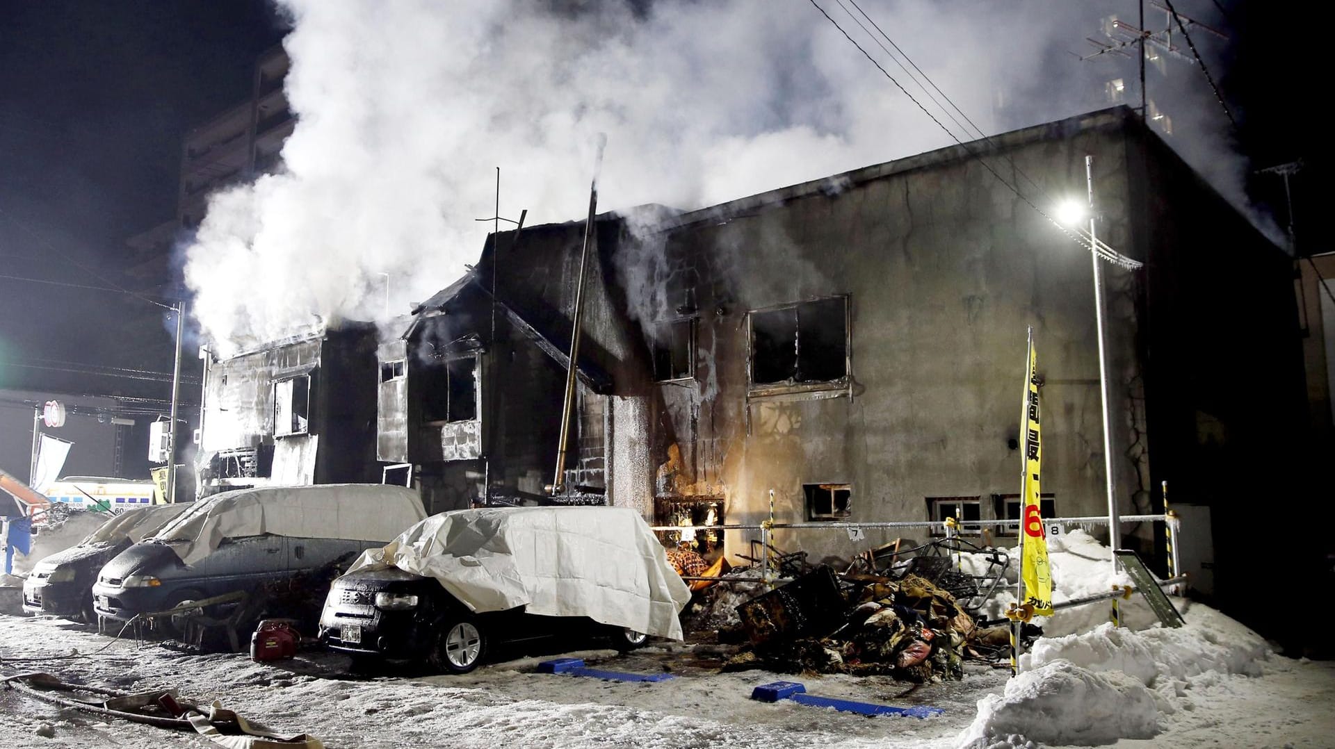 Rauch steigt nach einem Brand über einem Obdachlosenheim in der japanischen Stadt Sapporo auf: Bei einem Feuer in einem Heim für wohnungslose Menschen im Norden Japans sind elf Personen ums Leben gekommen. Rauch steigt nach einem Brand über einem Obdachlosenheim in der japanischen Stadt Sapporo auf: Bei einem Feuer in einem Heim für wohnungslose Menschen im Norden Japans sind elf Personen ums Leben gekommen.