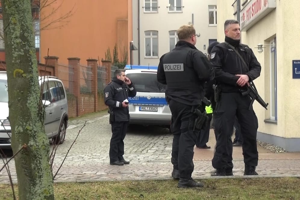 Polizisten vor dem Tatort in Waren an der Müritz: Nach dem Täter wird mit Hochdruck gesucht.