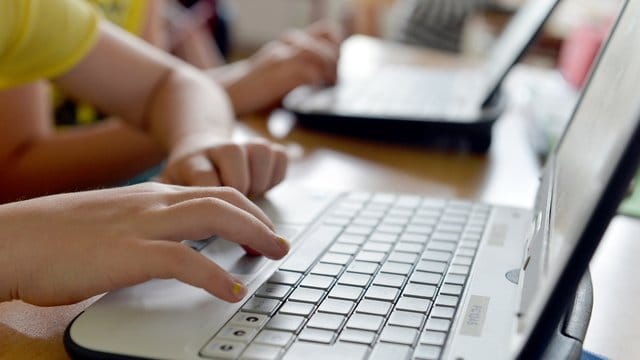 Eine Grundschülerin arbeitet an einem Laptop.
