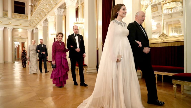 Herzogin Kate wird von König Harald von Norwegen zum Dinner geleitet – auch ihr Babybauch kommt in dem Alexander-McQueen-Kleid toll zur Geltung.