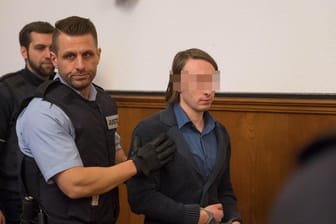 Sergej W. wird im Landgericht zur Anklagebank geführt: Der Angeklagte schlägt Schmerzensgeld für Opfer vor.