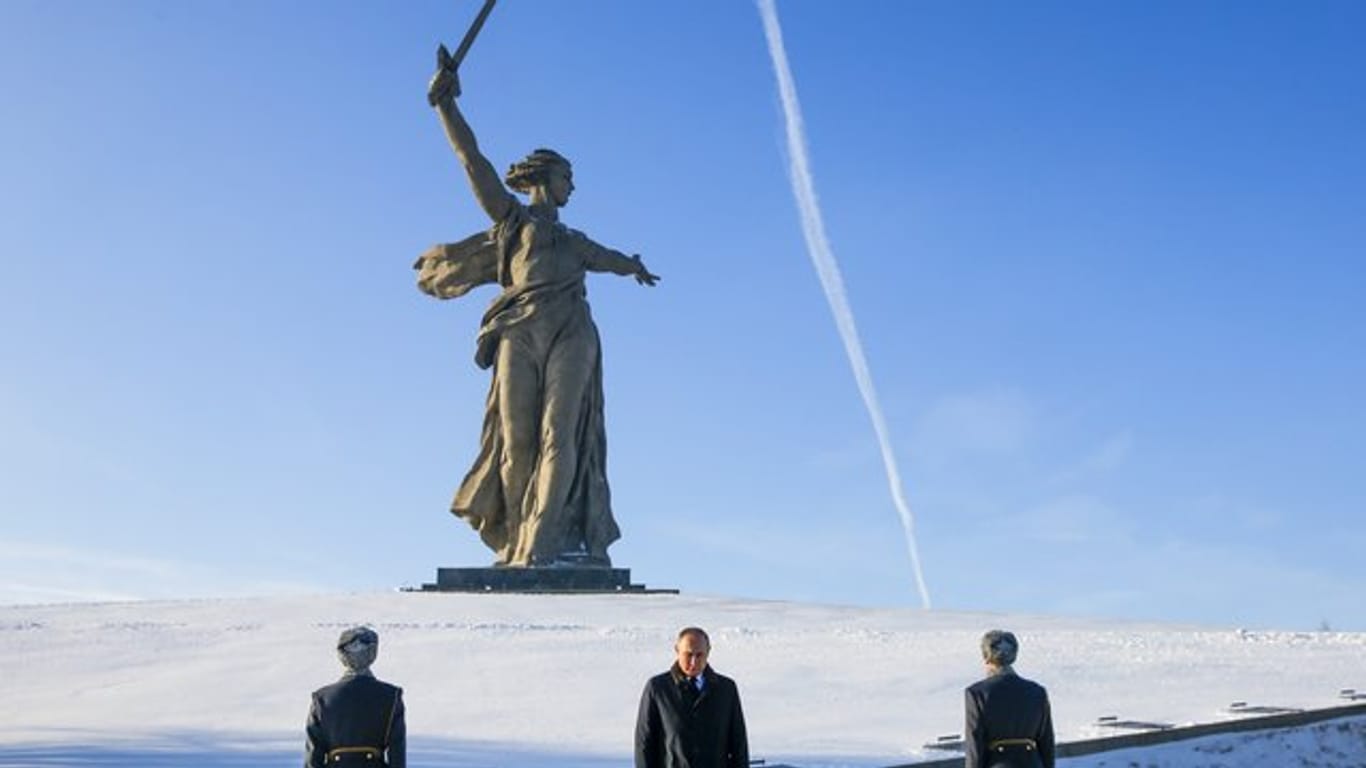 Der russische Präsident Wladimir Putin (M), nimmt an einer Zeremonie an der Mutter-Heimat-Statue in Wolgograd teil.