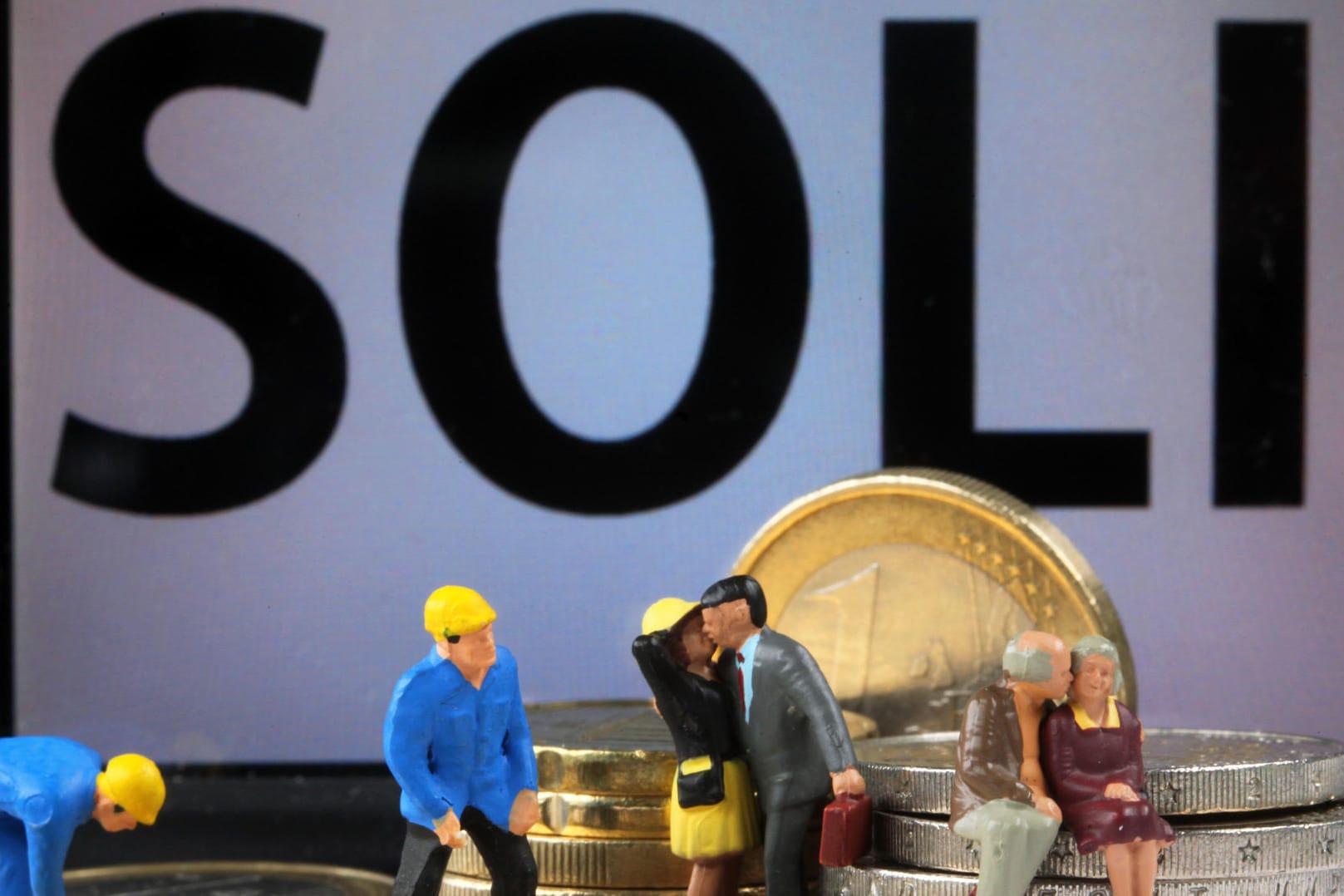 Modellfiguren mit Euro-Münzen: Union und SPD haben sich auf die schrittweise Abschaffung des Solidaritätszuschlags geeinigt. Modellfiguren mit Euro-Münzen: Union und SPD haben sich auf die schrittweise Abschaffung des Solidaritätszuschlags geeinigt.