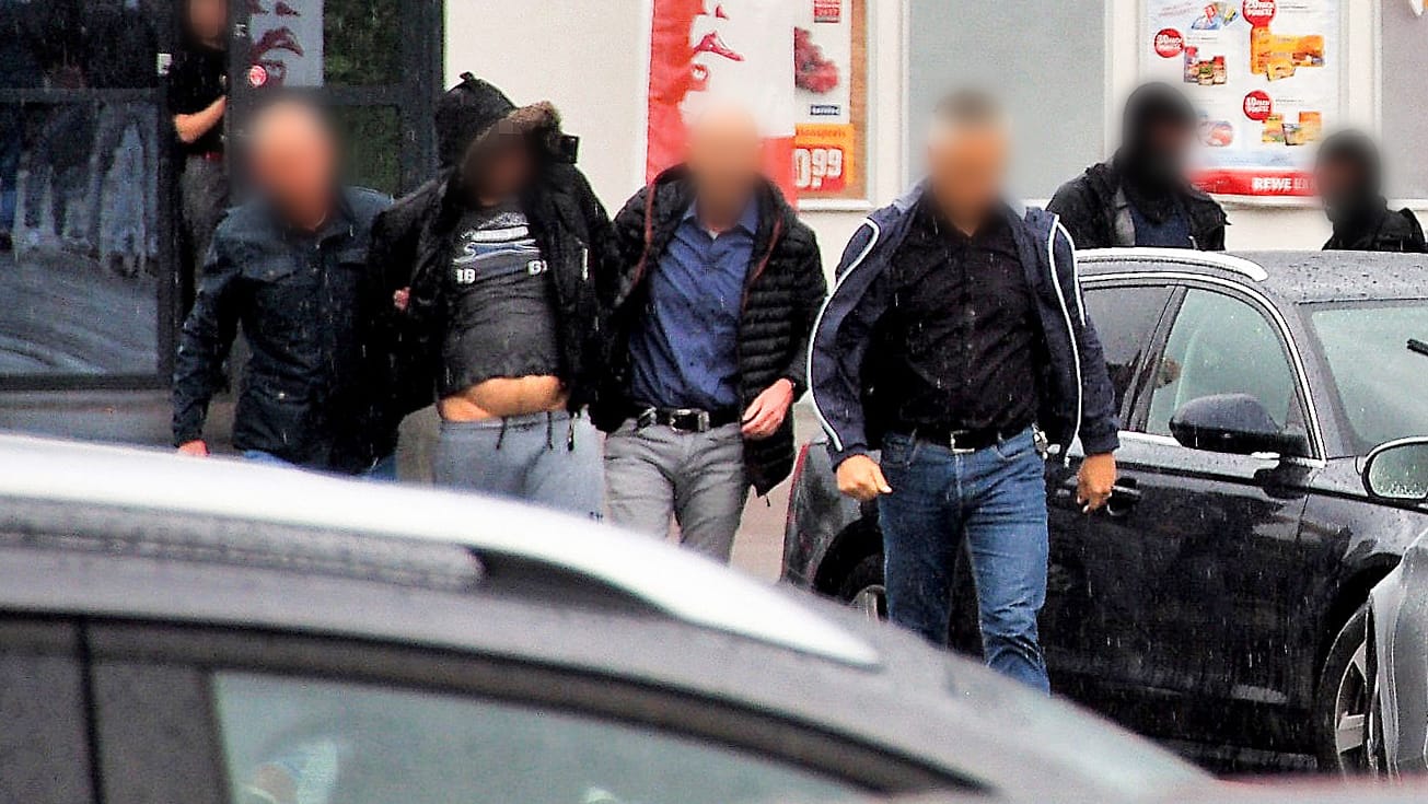 Ein Verdächtiger (2.v.l.) im Missbrauchsfall in Freiburg wird von Polizisten festgenommen. Den Ermittlungen zufolge hatten die Mutter und ihr Lebensgefährte einen neunjährigen Jungen übers Internet für Vergewaltigungen angeboten.