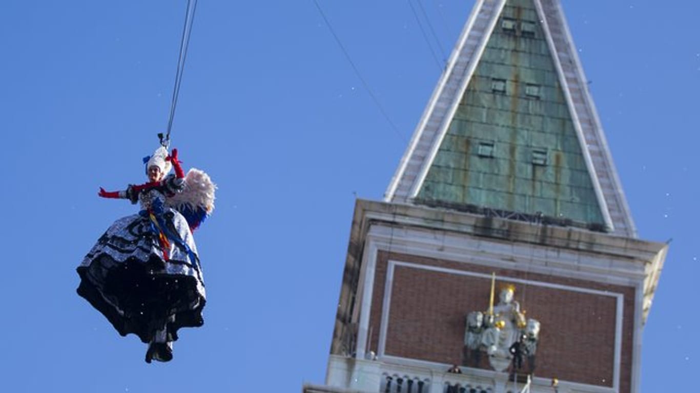 Elisa Costantini, als Engel verkleidet, schwebt beim Karneval in Venedig auf den Markusplatz.
