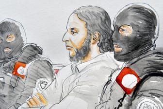 Abdeslam aus Sicht des Gerichtszeichners: Umringt von Spezialkräften der belgischen Polizei verfolgt der Terrorist den Prozess in Brüssel.